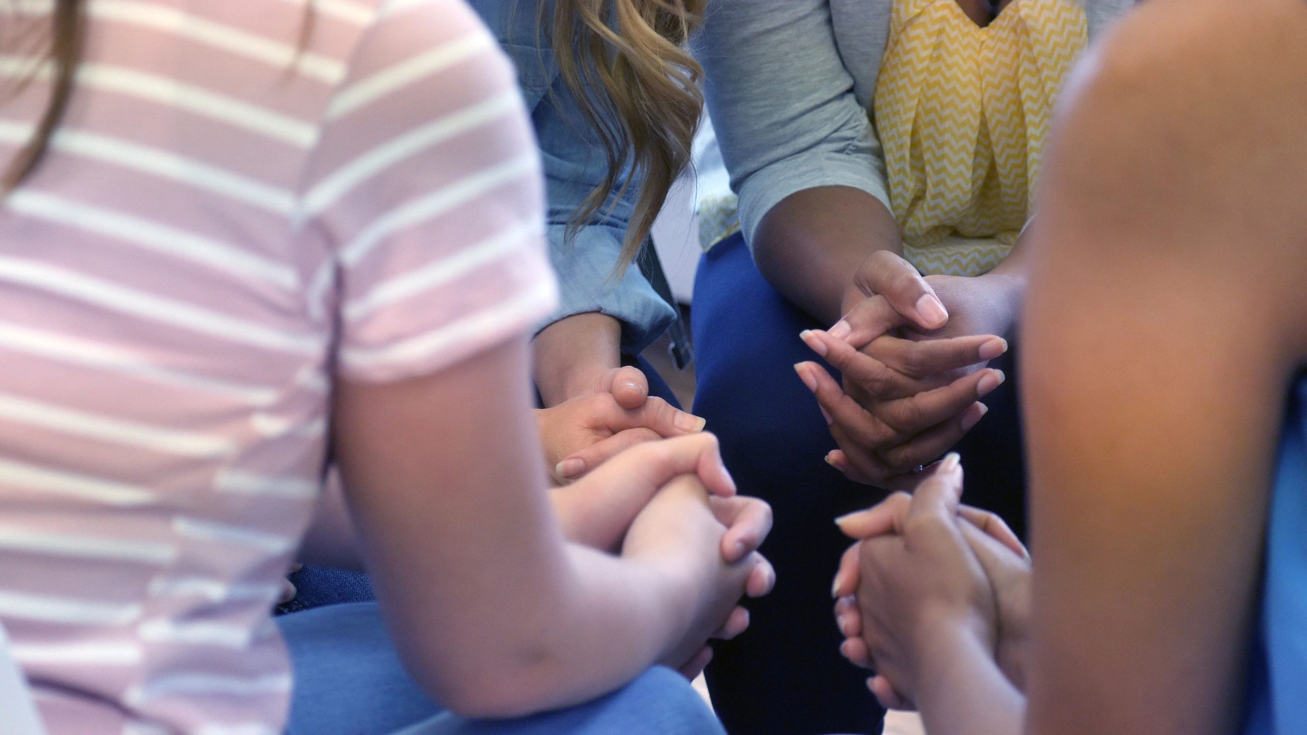 Group praying in a circle with hands clasped